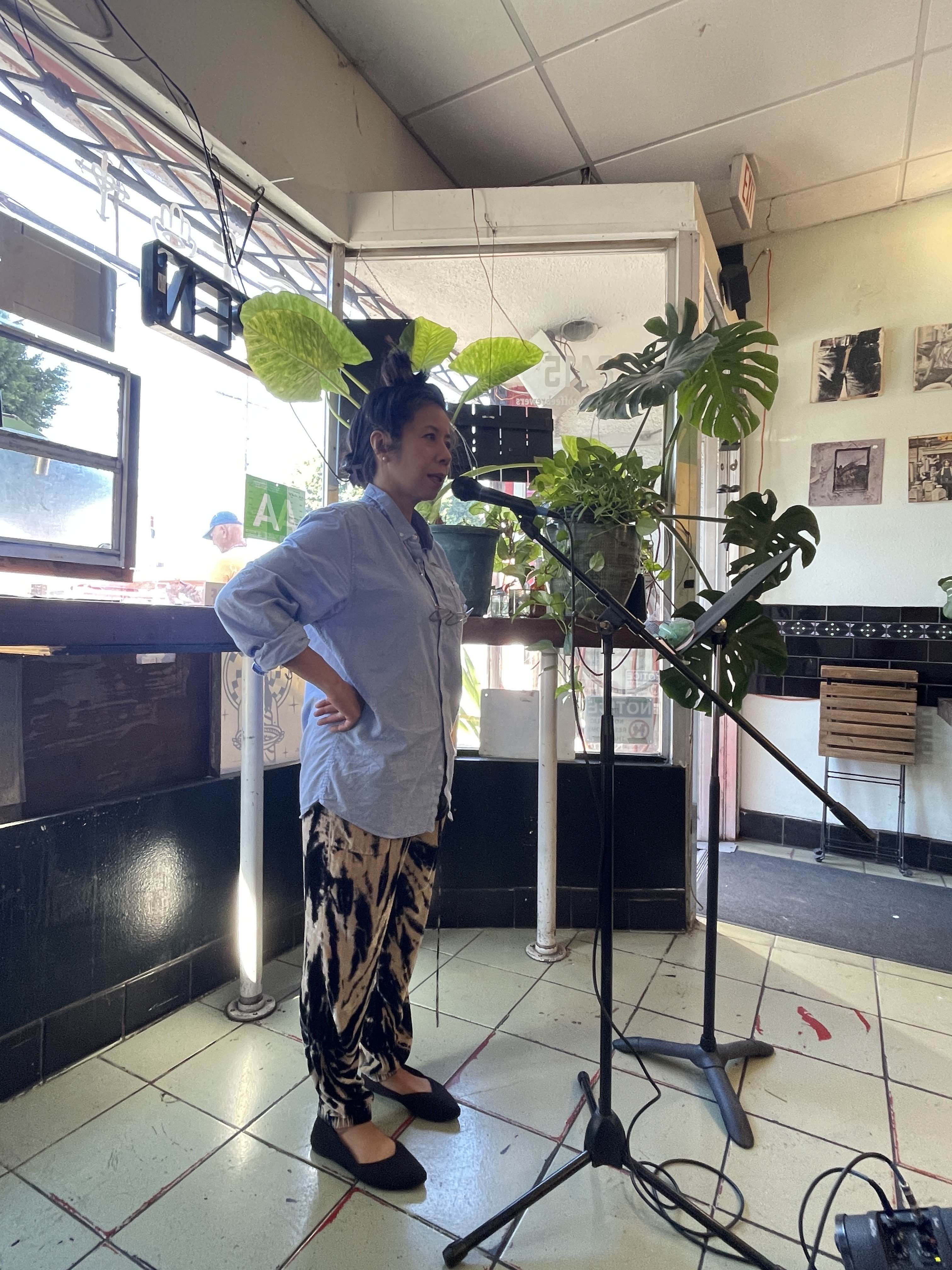 A participant reading their haiku at the microphone